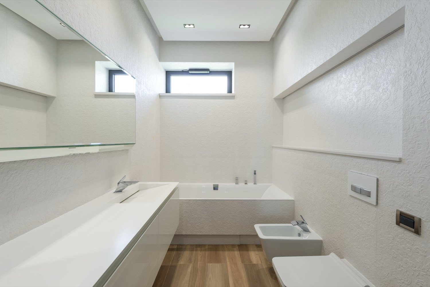 A plain bathroom with pipework hidden behind the wall