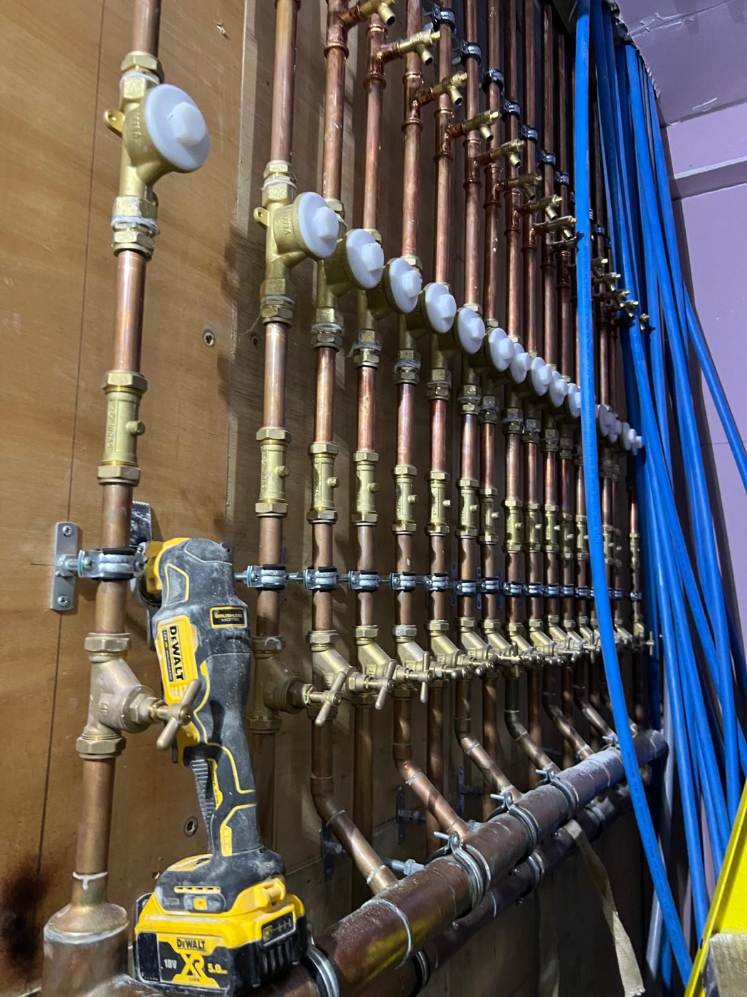 A wall of copper pipework with individual isolation valves